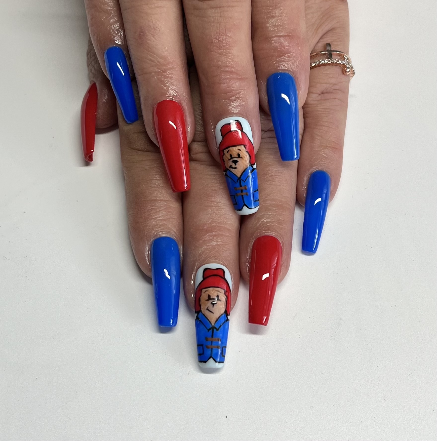 Long coffin nails in blue and red with hand-painted Paddington bear accent nail
